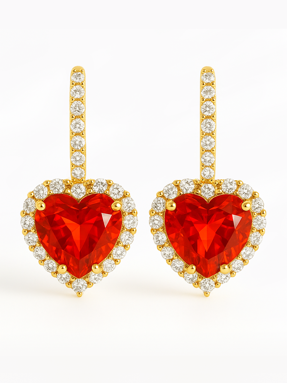 Heart-shaped red gemstone earrings with gold and diamond accents on a white background